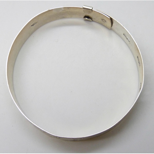 7105 - An engraved silver bangle, adjustable, 16g, 6.3cm, 1.3cm wide