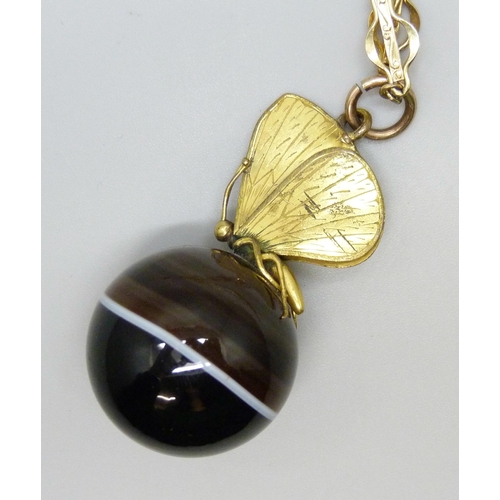 7129 - A large banded agate spherical pendant with butterfly mount, on a fancy link chain