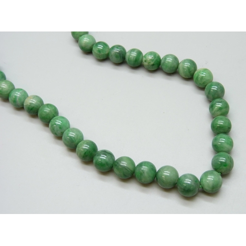 7130 - A string of nephrite beads, 77g, 50cm