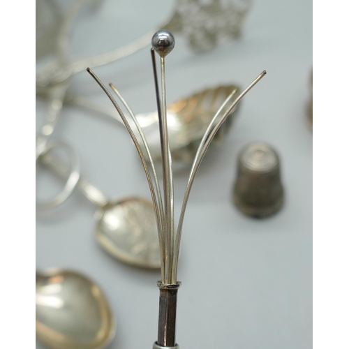 7243 - A collection of silver and white metal - a silver swizzle stick, silver mounted glass, a silver napk... 