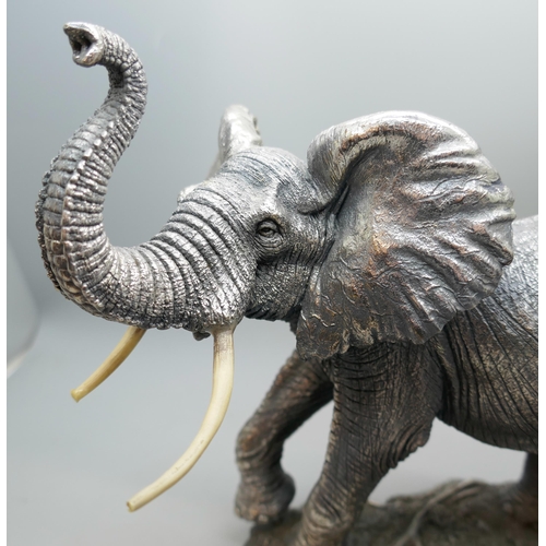 7251 - A hallmarked silver 'filled' model of an elephant, faux ivory tusks, 18.5cm tall