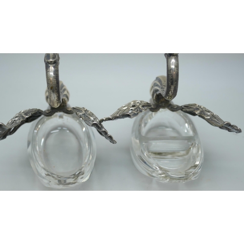 7260 - A pair of silver and glass swan salts, stamped 925, together with two silver salt spoons with cherub... 