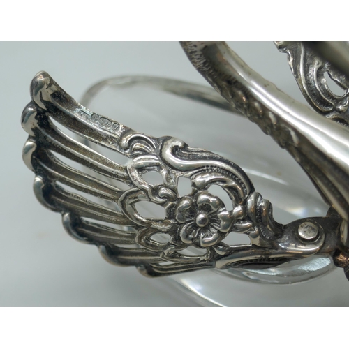 7260 - A pair of silver and glass swan salts, stamped 925, together with two silver salt spoons with cherub... 