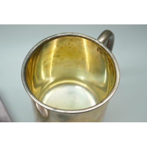 7269 - A silver mug with engraved monogram, Birmingham 1931, 114g, 8.5cm, together with a silver plated ash... 