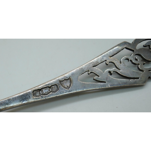 7273 - A silver tea strainer with fretwork handle, 43g, together with a silver shaker lacking liner, 43g