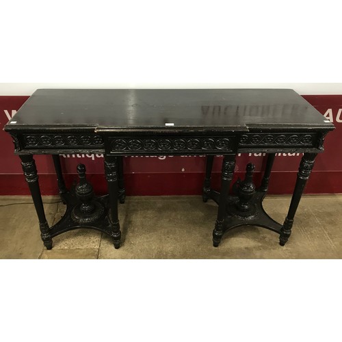 134 - An early 20th Century French carved ebonised breakfront single drawer console table