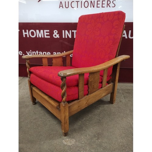 169 - An early 20th Century oak barleytwist reclining fireside armchair