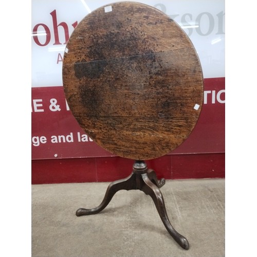 174 - A George III oak circular tilt top tripod tea table