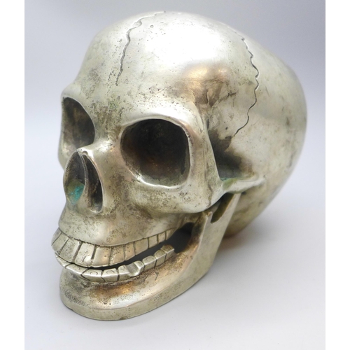 2026 - A novelty plated skull paperweight with hinge jaw, height 9cm