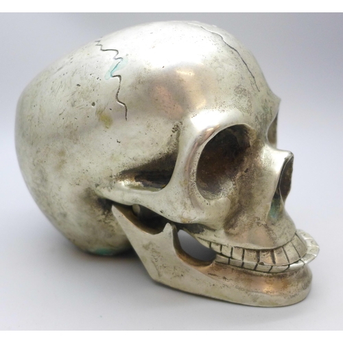 2026 - A novelty plated skull paperweight with hinge jaw, height 9cm