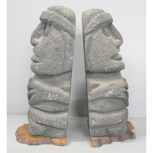 2211 - Two Easter Island bookends and an Inuit carved stone figure of a stylised polar bear devouring a sea... 