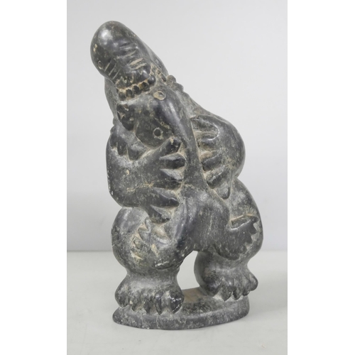 2211 - Two Easter Island bookends and an Inuit carved stone figure of a stylised polar bear devouring a sea... 