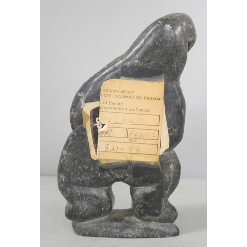 2211 - Two Easter Island bookends and an Inuit carved stone figure of a stylised polar bear devouring a sea... 