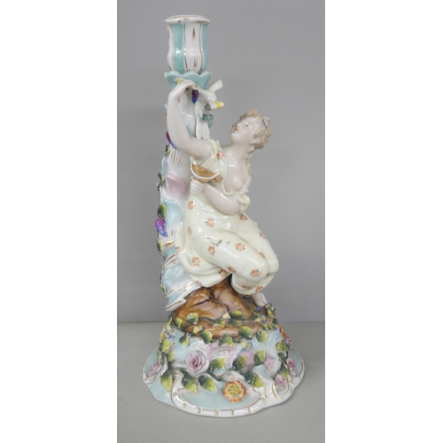 2216 - A German porcelain figural candlestick with floral relief detailing to base