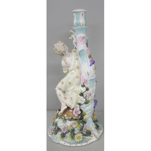 2216 - A German porcelain figural candlestick with floral relief detailing to base