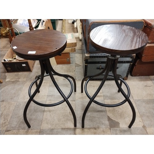 296 - A pair of stained pine and black tubular metal rise and fall bar stools