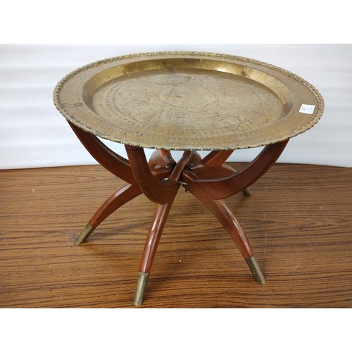 309 - An Eastern brass topped folding occasional table