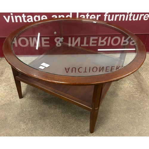 38 - A teak and glass topped circular coffee table