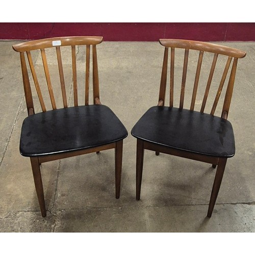 39 - A pair of teak and black vinyl dining chairs