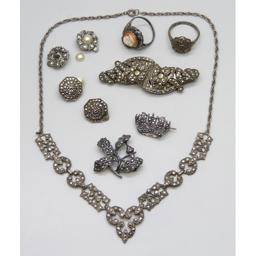 7063 - A silver necklace, two silver rings, two silver brooches, 33g, together with two pairs of plated ear... 