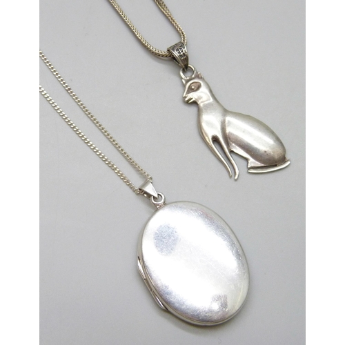 7077 - Two silver lockets and chains and a silver cat pendant, 28g