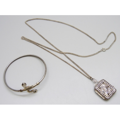 7080 - A silver snake bangle and a white metal filigree locket and chain, locket closure a/f