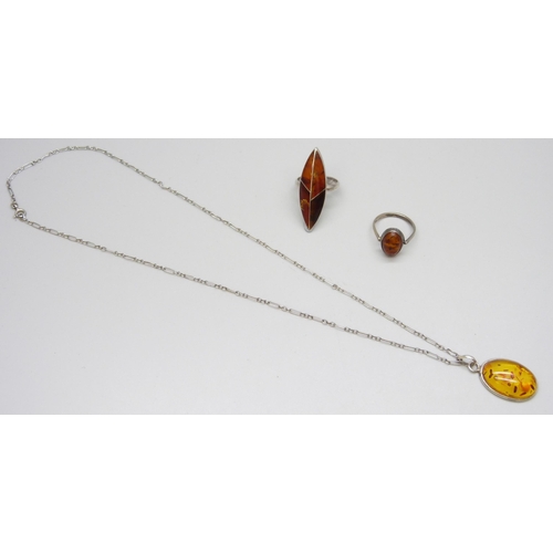 7082 - A silver amber set ring, a silver mounted amber pendant on chain, and a white metal amber ring