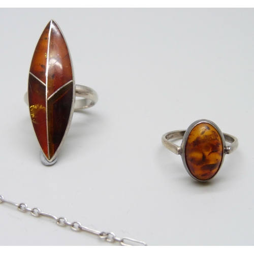 7082 - A silver amber set ring, a silver mounted amber pendant on chain, and a white metal amber ring