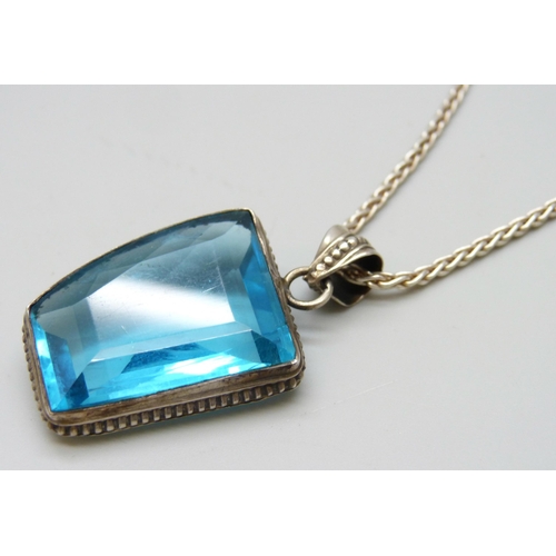 7083 - A silver and blue glass set pendant and a silver chain, 22g, 4.2cm including bale