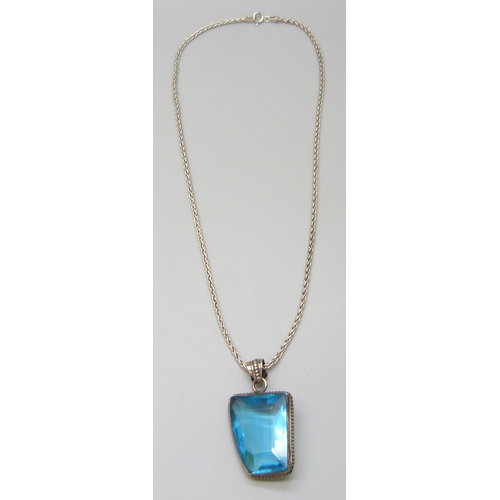 7083 - A silver and blue glass set pendant and a silver chain, 22g, 4.2cm including bale