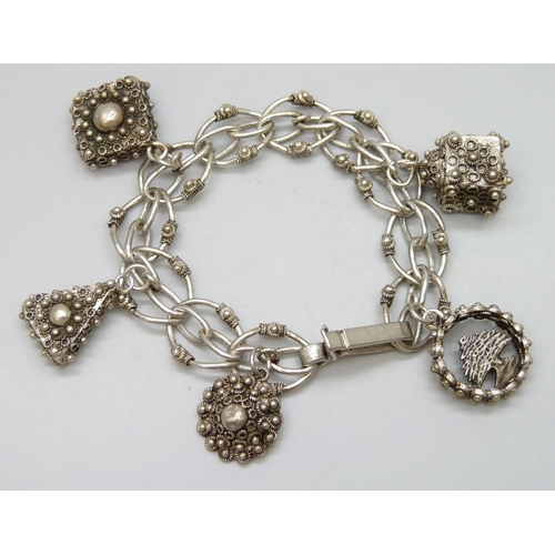 7087 - A vintage silver Etruscan Revival style bracelet with white metal charms, 46g