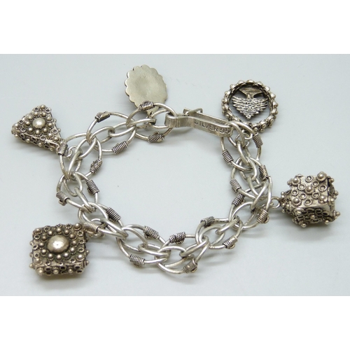 7087 - A vintage silver Etruscan Revival style bracelet with white metal charms, 46g