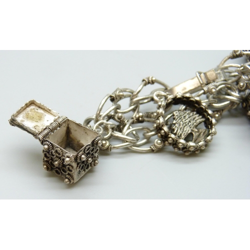 7087 - A vintage silver Etruscan Revival style bracelet with white metal charms, 46g