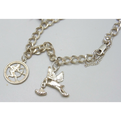 7088 - A sterling silver charm bracelet with charms, 16g