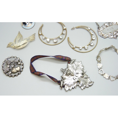 7107 - Two silver brooches, a white metal brooch, a silver bracelet, together with badges, spirit labels, W... 