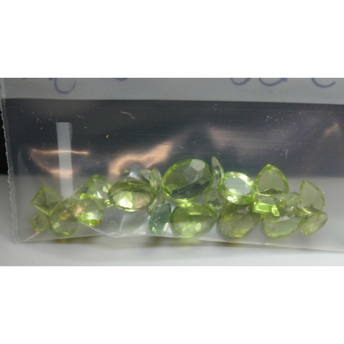 7143 - Gemstones - A collection of peridot, 13.8ct total, and garnet, 41.7ct total, and a magnetic display ... 