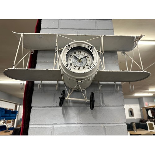 3218 - A plane wall clock with shelving and coat hooks