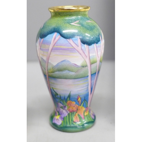 2013 - An enamelled Moorcroft miniature vase with lake scene and a similar pill box with peacock detail, bo... 