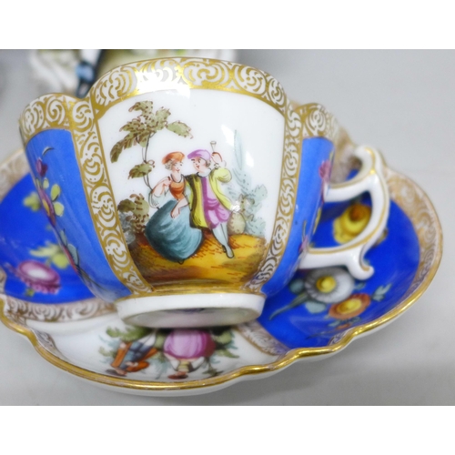 2086 - A pair of early 20th Century German porcelain figures and two Dresden cups and saucers, (fingers on ... 