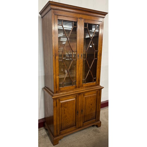 113 - A George III style elm four door display cabinet