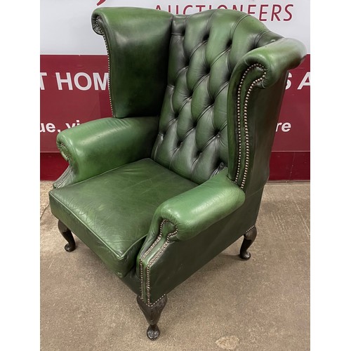 63 - A mahogany and green leather Chesterfield wingback armchair