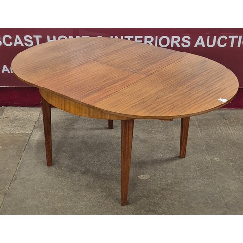 11 - A teak circular extending dining table