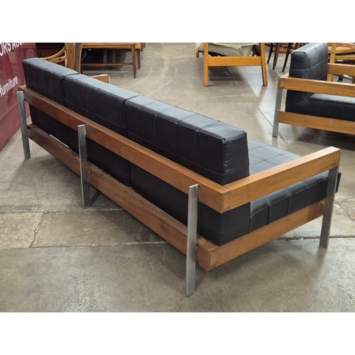 29 - A Danish style teak, chrome and black leather three piece lounge suite, comprising; two armchairs an... 