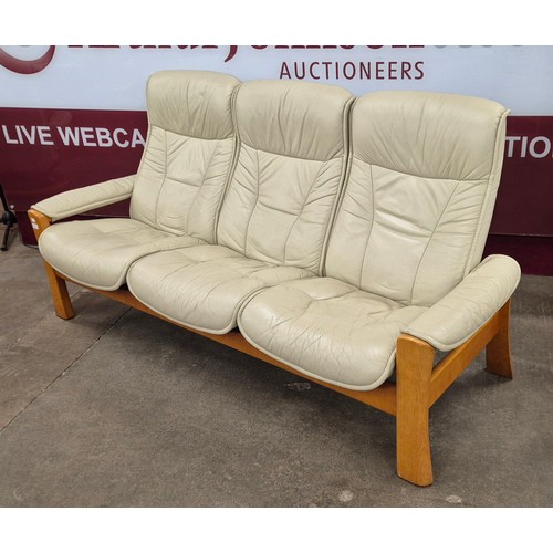 32 - A Norweigian Ekornes beech and cream leather Stressless five piece lounge suite, comprising; two rev... 