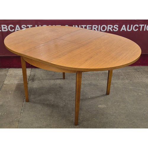 53 - A teak circular extending dining table and four chairs