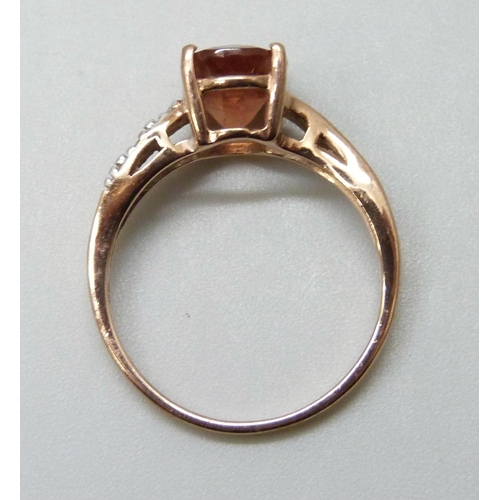 7020A - A 9ct gold ring set with a peach faceted glass stone and diamonds, 2.1g, O