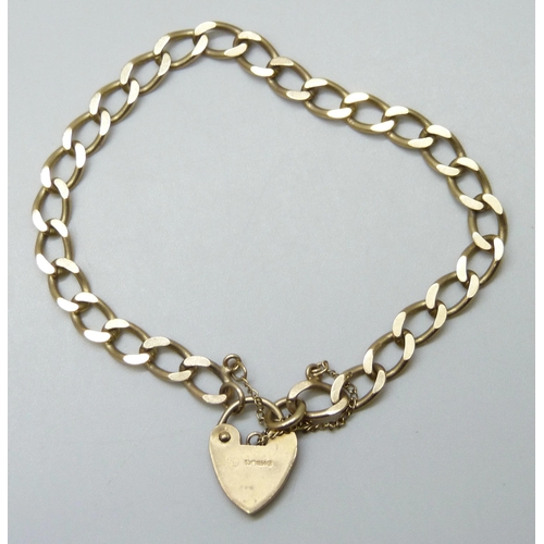 7058 - A 9ct gold curb bracelet with padlock fastener, 10.4g