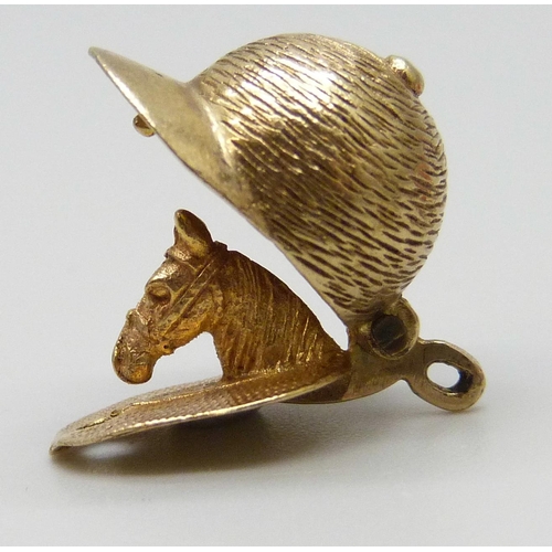 7074 - A 9ct gold jockey's cap charm opening to reveal a horse's head, 3.9g, a yellow metal charm with Arab... 