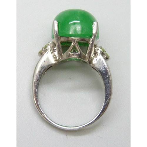 7104 - A silver ring set with an 11ct green jade central stone with peridot set shoulders, O