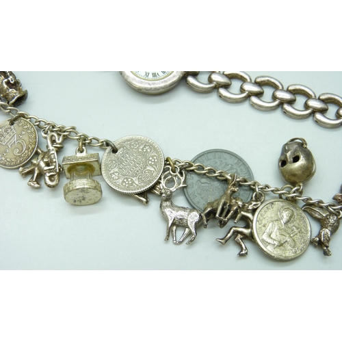 7133 - A white metal charm bracelet with a collection of silver and white metal charms, a silver napkin rin... 